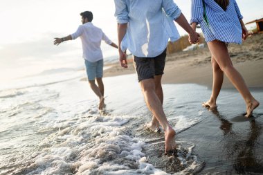 Mutlu mutlu çift gün batımında tropik bir plajda eğleniyor. Romantik tatil kavramı