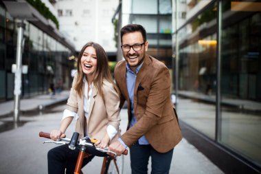 Genç çift şehirde eğleniyor. Bisiklete binen mutlu genç çift