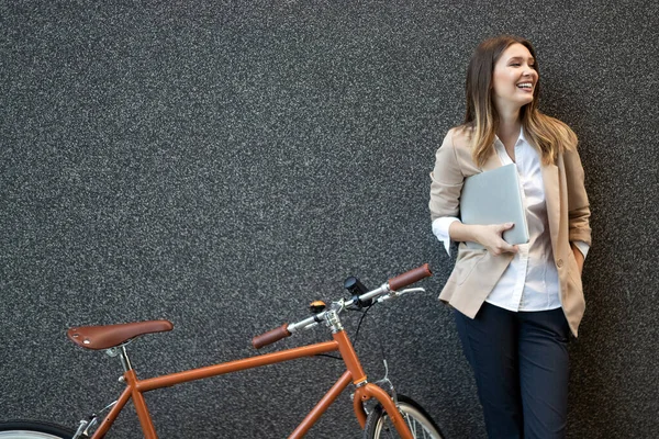 Happy business woman with bicycle to work on urban street in city. Transport and healthy lifestyle concept