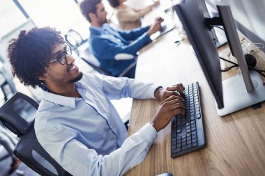 Modern bilişim şirketinde işbirliği yapan programcılar uygulama geliştiriyor