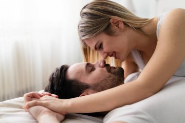 Genç mutlu çift yatak odasında romantik vakit geçiriyor