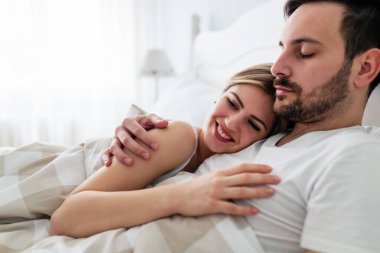 Genç mutlu çift yatak odasında romantik vakit geçiriyor