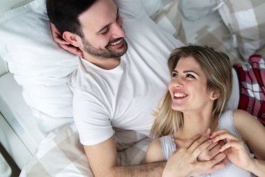 Genç mutlu çift yatak odasında romantik vakit geçiriyor