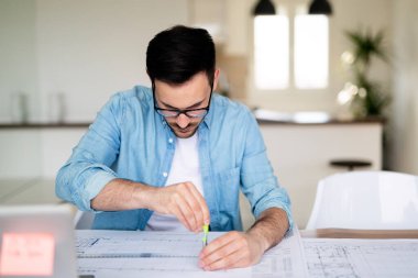 Ofiste planlar üzerinde çalışan zeki genç bir işadamının portresi.