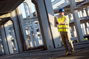 Genç iş adamı inşaat sitesi mühendis mavi baskı ile