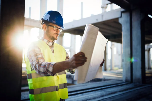 Selbstbewusster Architekt Hält Eingerollte Baupläne Auf Baustelle Hoch — Stockfoto