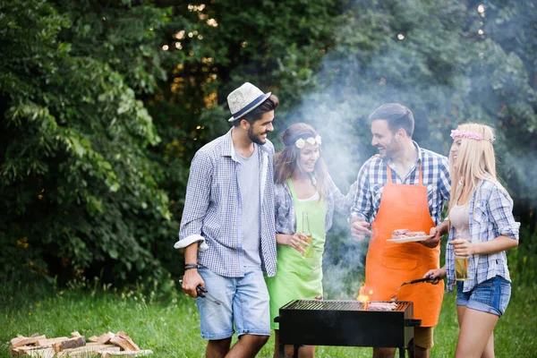 Friends making a barbecue together outdoors in the nature