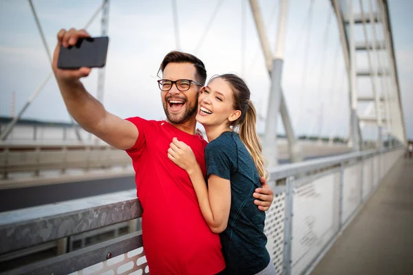 Sport happy man and woman making selfies. Happy couple hugging and posing for camera