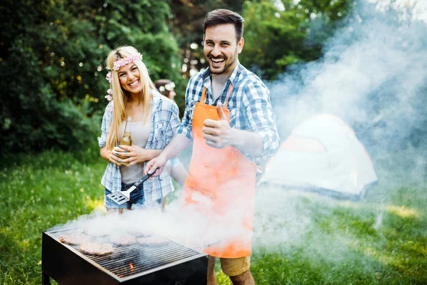 Kjekk Ung Mann Som Lager Grillmat Utendørs Til Venner – stockfoto