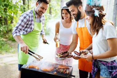 Arkadaşlar doğada barbekü yaparken eğleniyorlar.