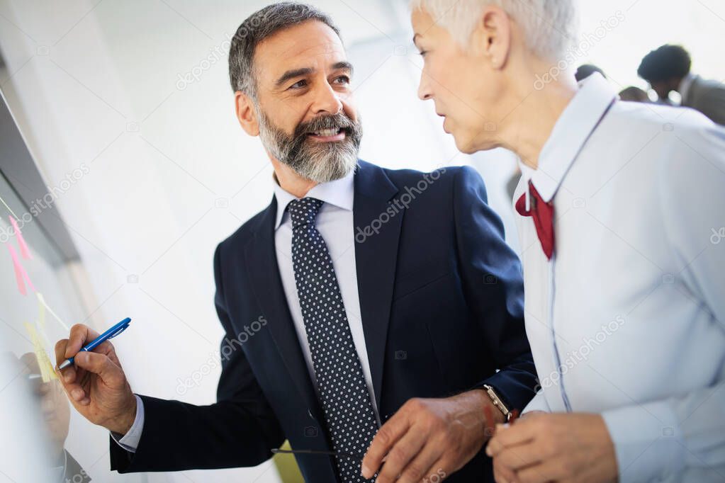 Portrait of happy business people discussing working together in office