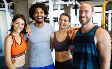 Spor salonunda egzersiz yapan bir grup sağlıklı genç.