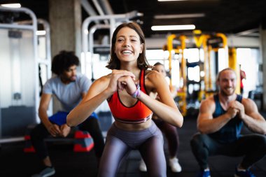 Spor salonunda egzersiz yapan çekici ve formda bir kadının görüntüsü.