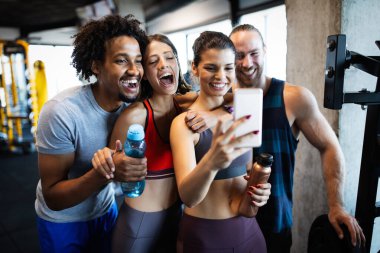 Spor salonunda selfie çeken sağlıklı bir grup insan. Bir fitness kulübünde yaşam tarzı ve spor konseptleri