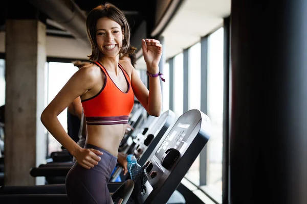 Close up image of attractive fit woman exercising in gym