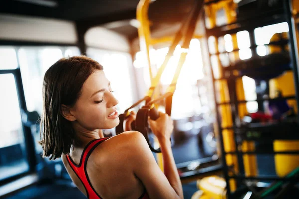 Close up image of attractive fit woman exercising in gym