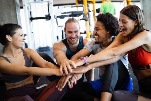 Group of young fit people doing exercises in gym