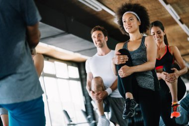 Güzel fit insanlar, spor salonunda birlikte egzersiz yapan arkadaşlar.