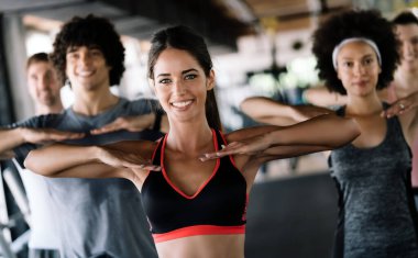 Spor salonundaki mutlu bir grup sporcu. Bir fitness kulübünde yaşam tarzı ve spor konseptleri