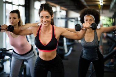 Güzel fit insanlar, spor salonunda birlikte egzersiz yapan arkadaşlar.