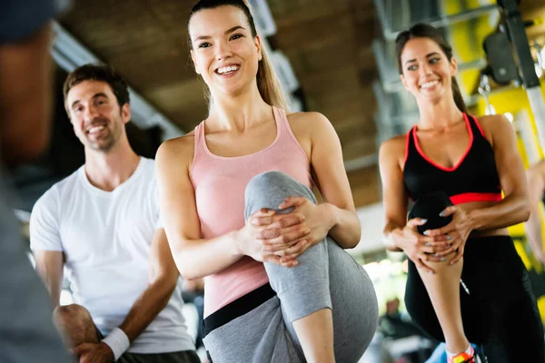 Group of athletic people working out in gym