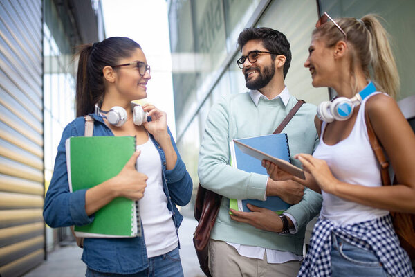 Счастливые молодые студенты университета, учащиеся с книгами в университете. Группа людей в колледже
