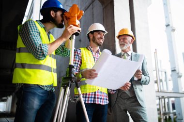 Mühendis, ustabaşı ve işçi inşaat alanında tartışıyor ve çalışıyor.