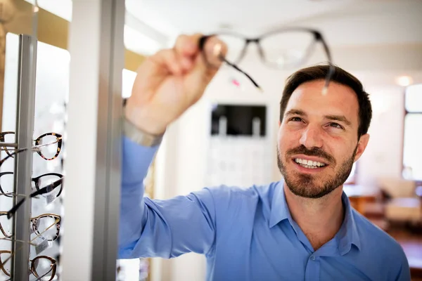 Handsome Young Man Choosing Glasses Optics Store — Stock Photo, Image