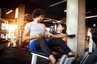 Spor salonunda fit insanlarla egzersiz yapan beden eğitimi hocası..