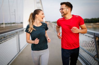 Spor, spor, insanlar, egzersiz ve yaşam tarzı konsepti. Dışarıda koşan zinde bir çift.