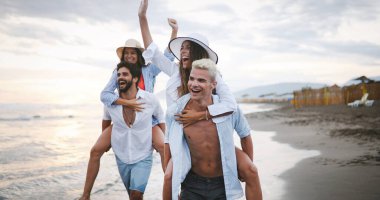 Grup mutlu genç arkadaşlar plajın tadını çıkarıyorlar, birlikte yaz tatili.