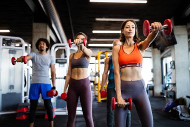 Mutlu insanlar sağlıklı kalmak için spor salonunda birlikte egzersiz yaparlar. İnsanlar spor eğitimi kavramları