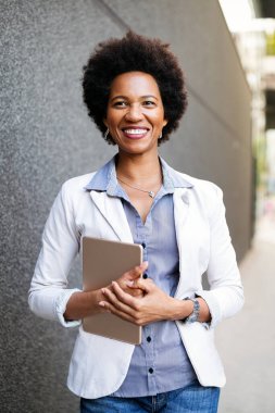 Şehirde dijital tabletli mutlu iş kadını