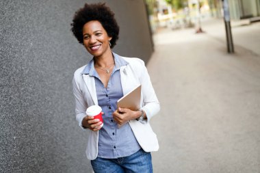 Mutlu iş kadını şehirde kahve molası için tablet kullanıyor.