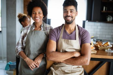 Güzel genç çift evde yemek pişirirken eğleniyor ve gülüyor.