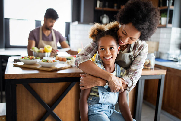 Happy african american family preparing healthy food in kitchen together