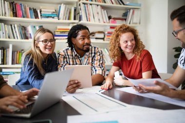 Genç mimar meslektaşları ofiste yeni bir proje üzerinde çalışırken projeleri analiz ediyorlar..