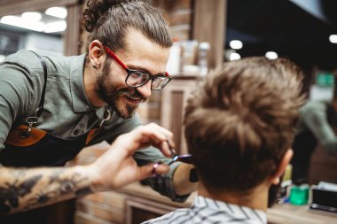 Berber dükkanında bıyık ve sakal bırakan yakışıklı bir adam.