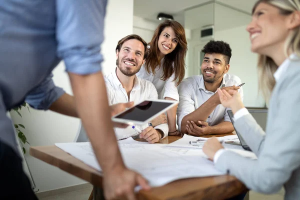 Modern bir ofiste iş adamları birlikte çalışıyor.