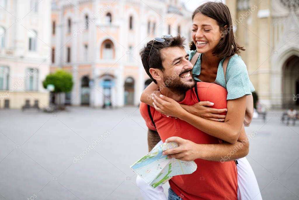 Happy couple on vacation having fun and sightseeing city with map