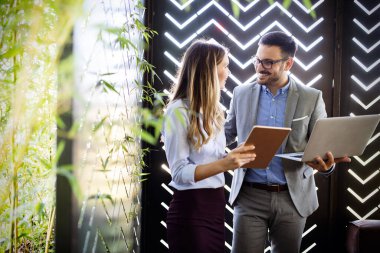 Girişim ekibi, modern ofis içi beyin fırtınası, dizüstü bilgisayar ve tablet bilgisayar üzerine toplantı üzerine çalışıyor