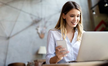 İş kadını telefona gülümseyerek cevap veriyor, iyi haberler alıyor.