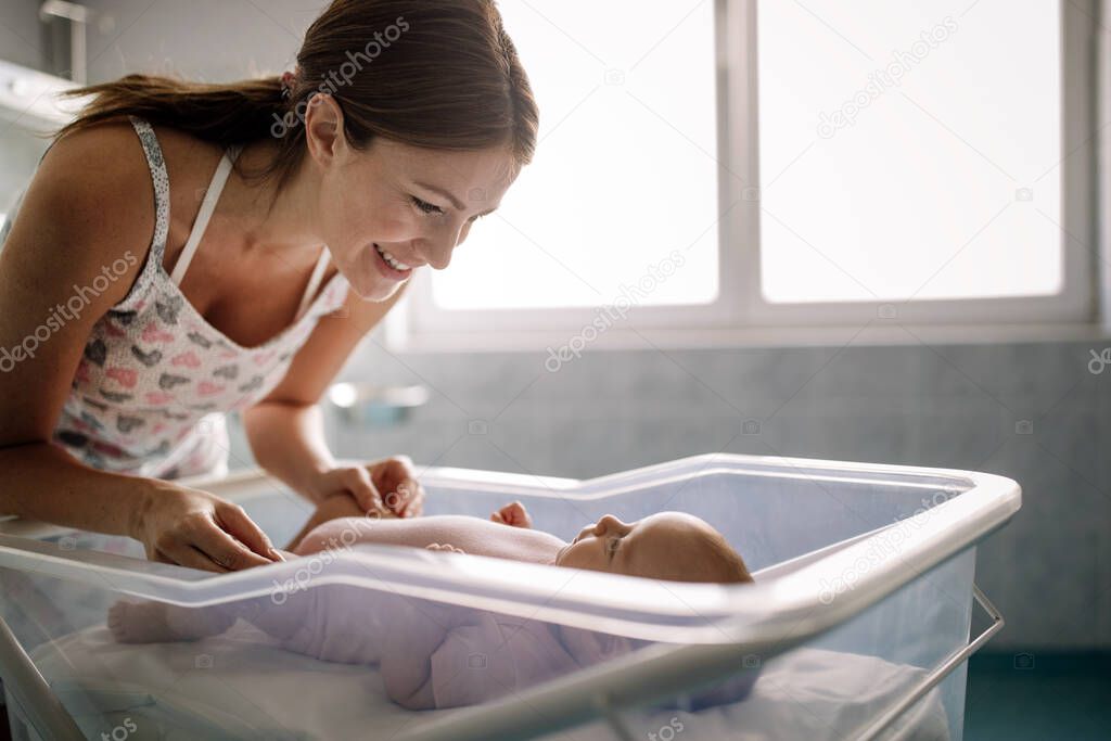 Portrait of happy mother playing with sweet baby girl