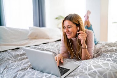 Evde dizüstü bilgisayar kullanan sıradan, güzel bir kadın.