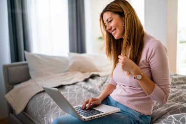 Evde dizüstü bilgisayarı olan mutlu bir kadın. Teknoloji, insanlar konsepti