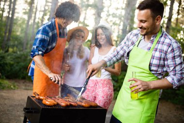 Arkadaşlar kamp yapıyor ve doğada barbekü partisi veriyor.
