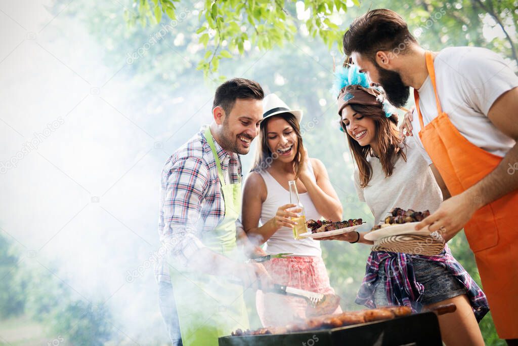 Friends having fun in nature doing barbecue