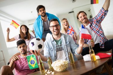 Çok ırklı bir grup insan futbol maçını kutluyor ve eğleniyor.