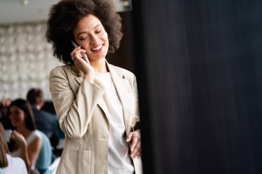 Güzel Afrikalı başarılı şirket çalışanı cep telefonuyla konuşuyor.