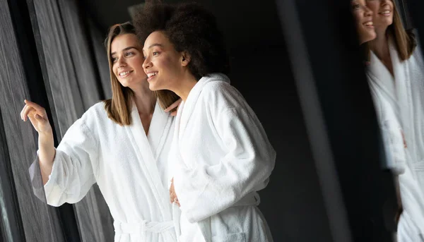 Portrait of happy women in robes talking with her friend